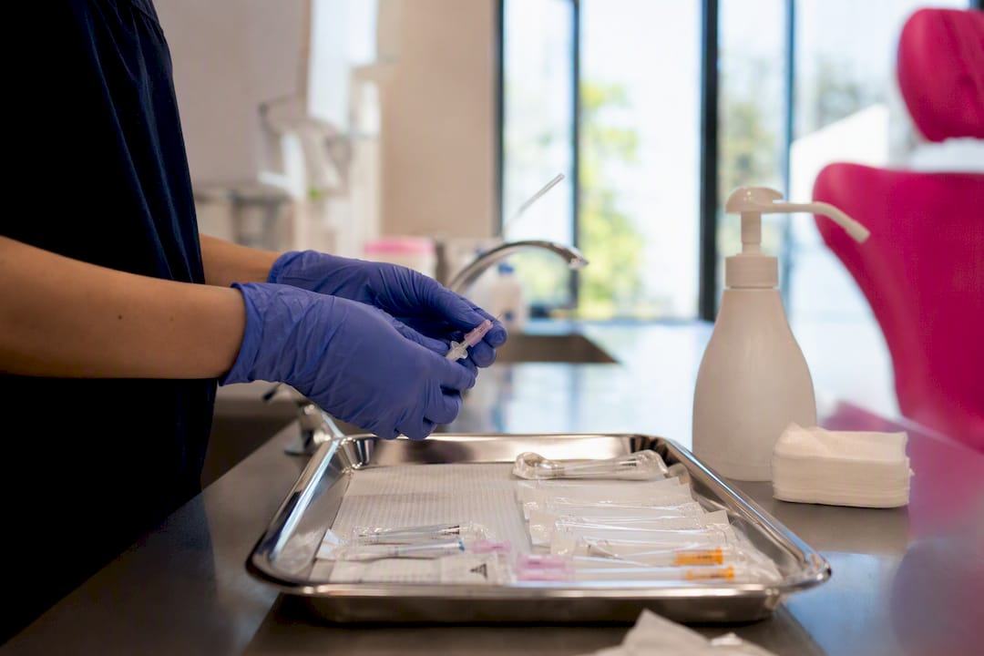 Hands preparing cannula and needle in clinic